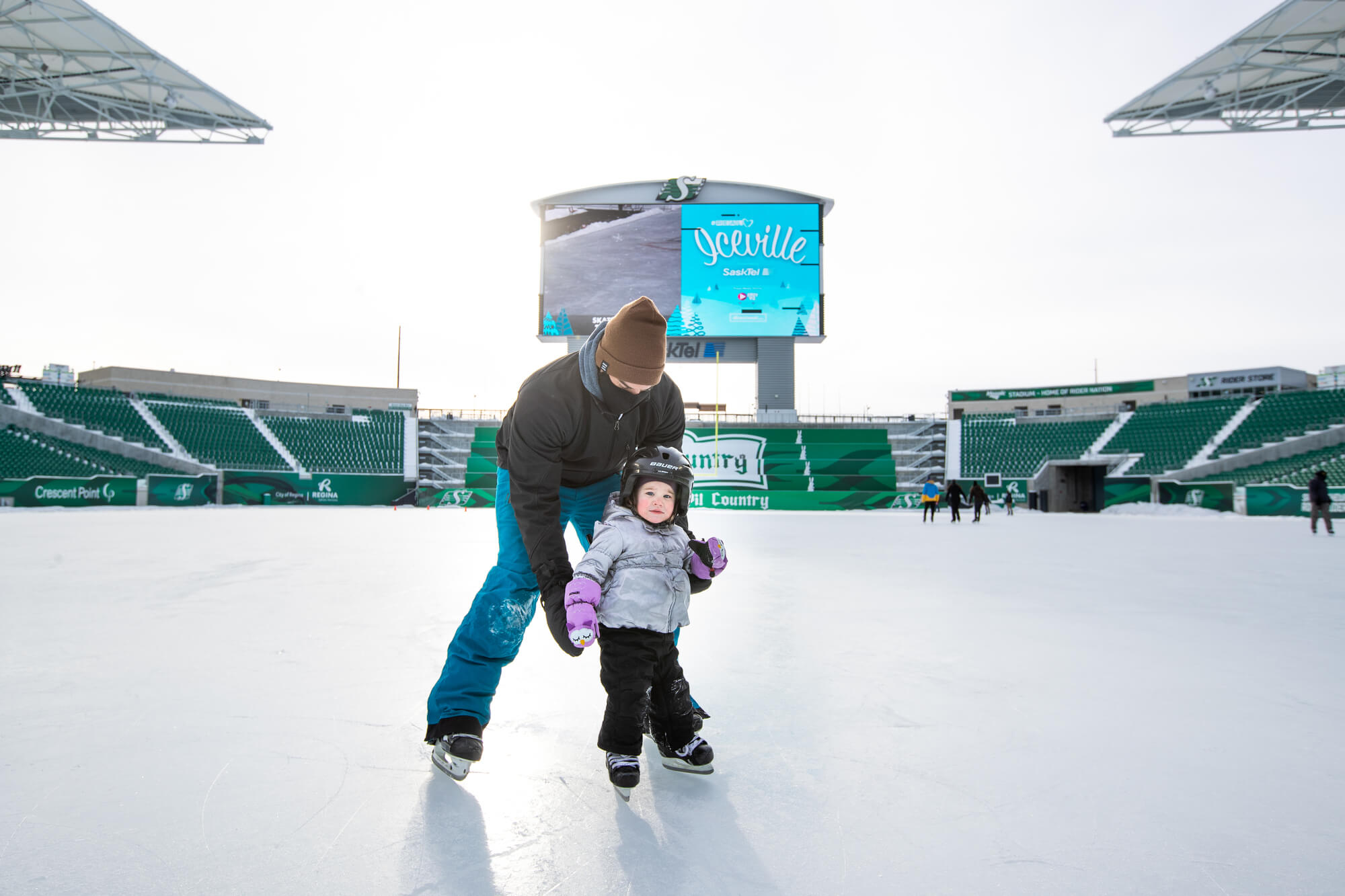 Family skating on an outdoor rink located at Mosaic Stadium, Regina, SK
