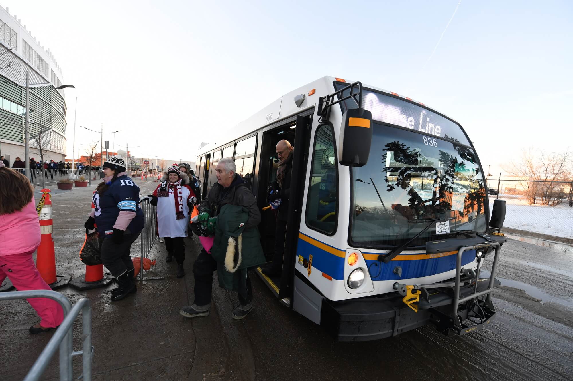 People getting off a bus outside of Mosaic Stadium in Regina