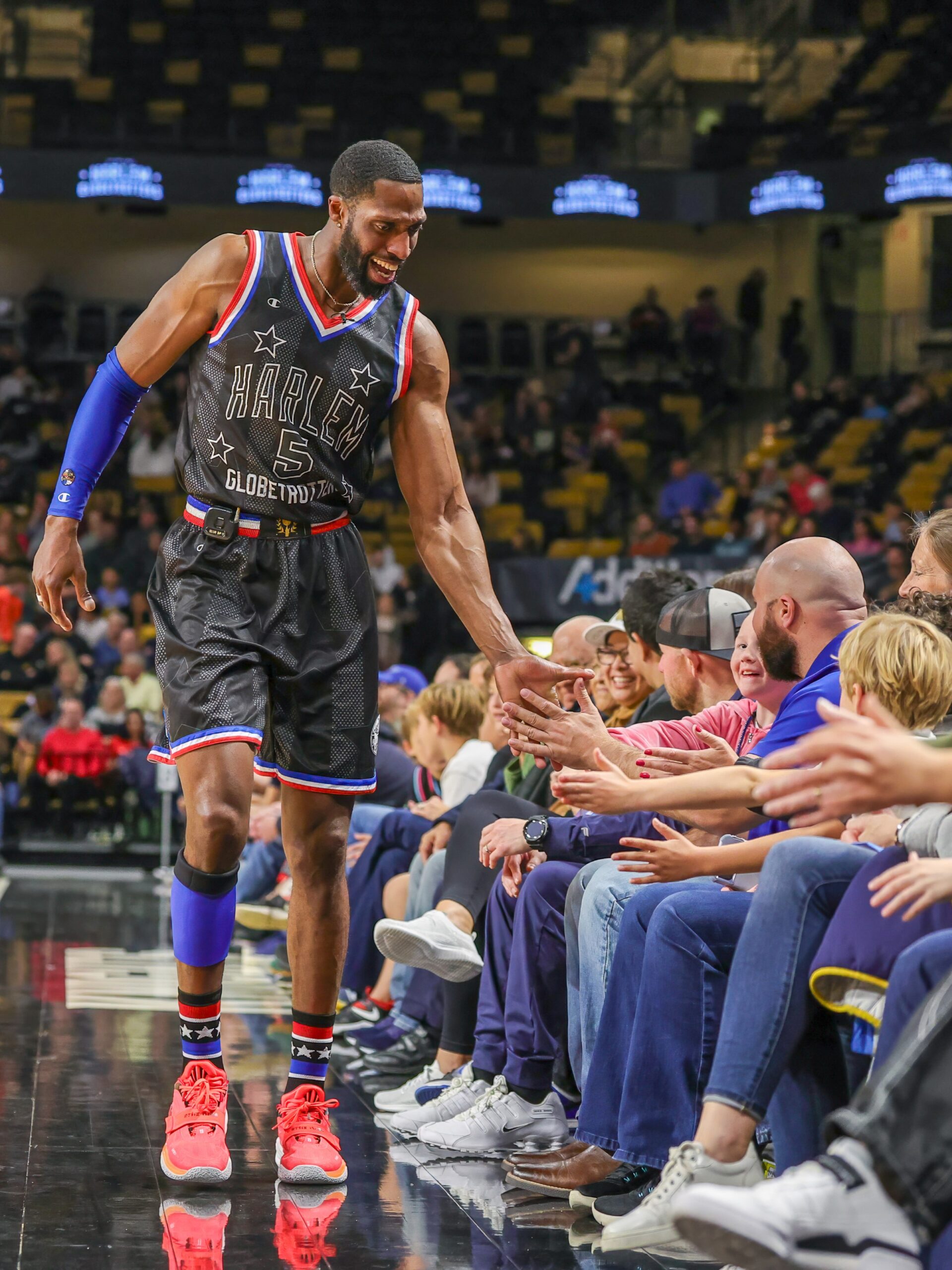 Basketball player high-fives audience at game