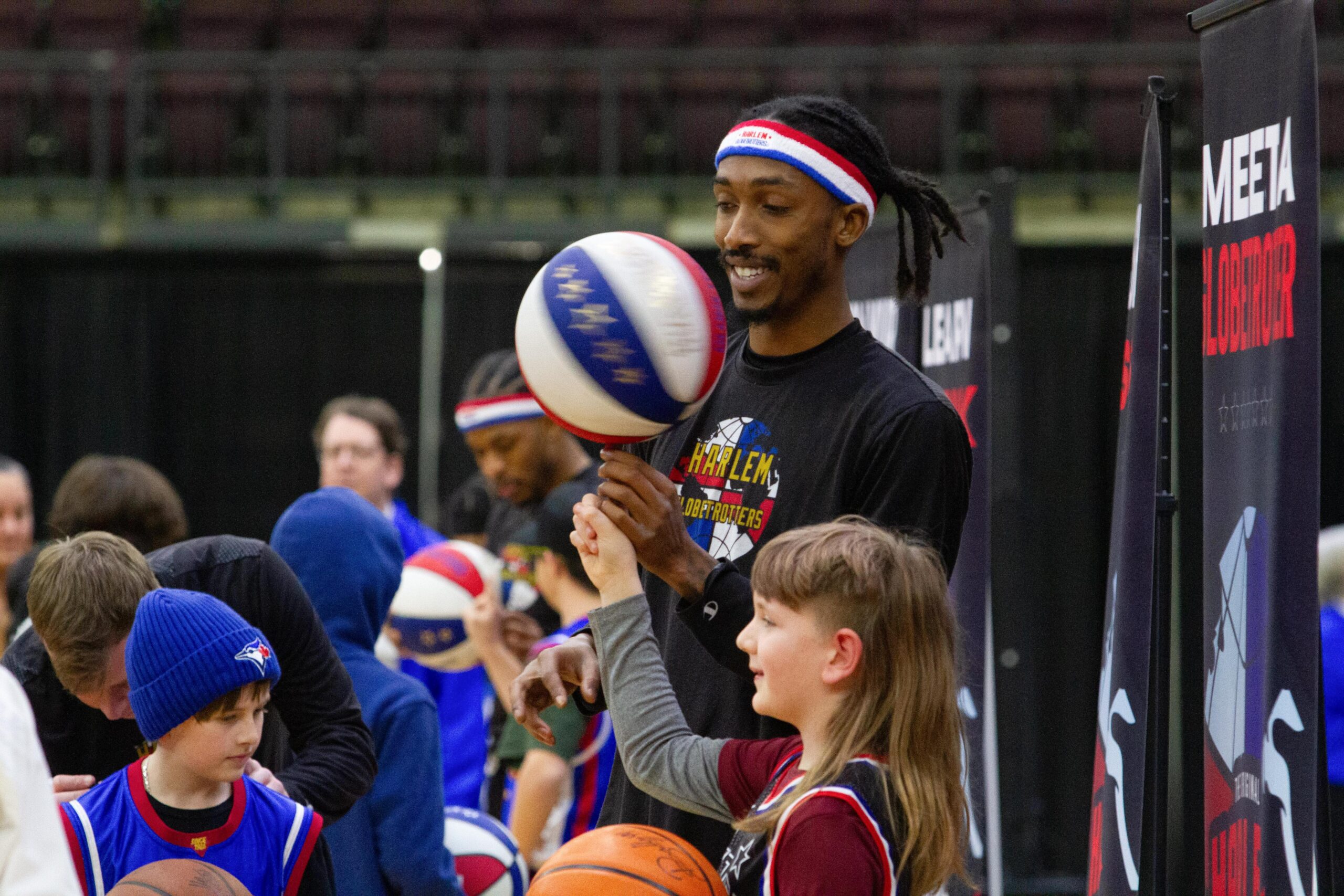 Basketball player teaches kids ball spinning.