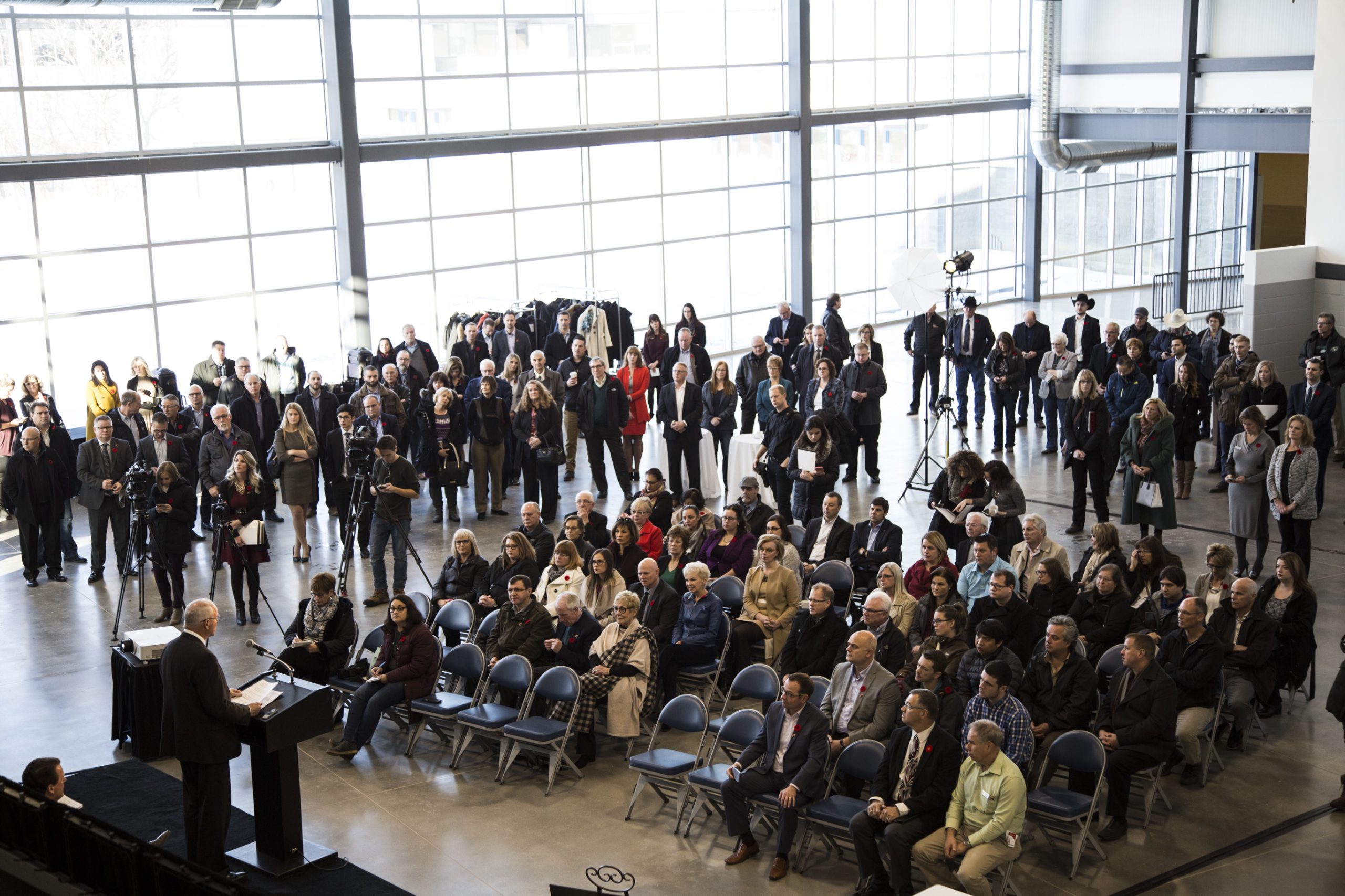 Speaker addresses large audience in conference hall.