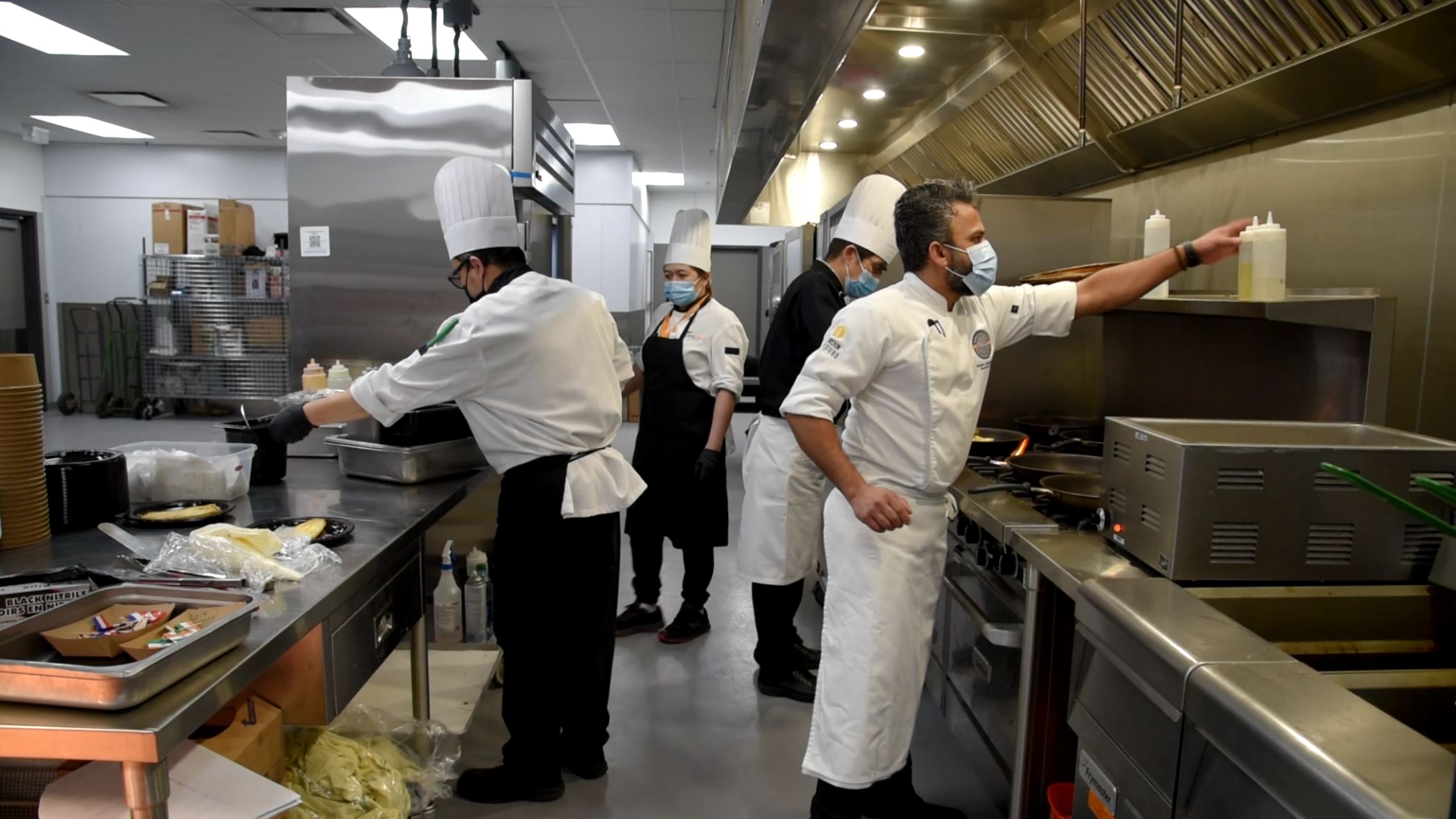 Chefs cooking in a restaurant kitchen.
