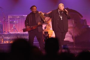 Musicians performing live concert on stage.