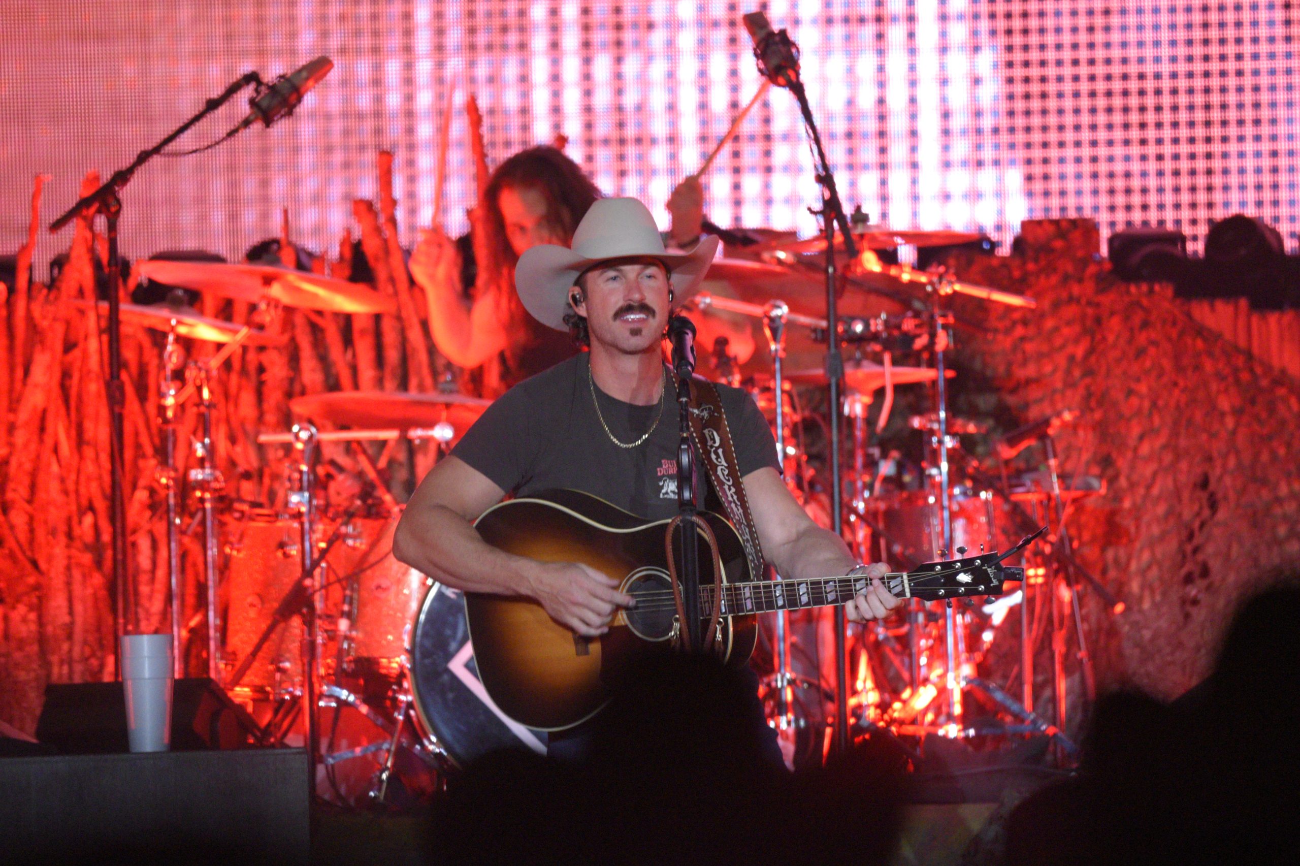 Country musician performs on stage with guitar.