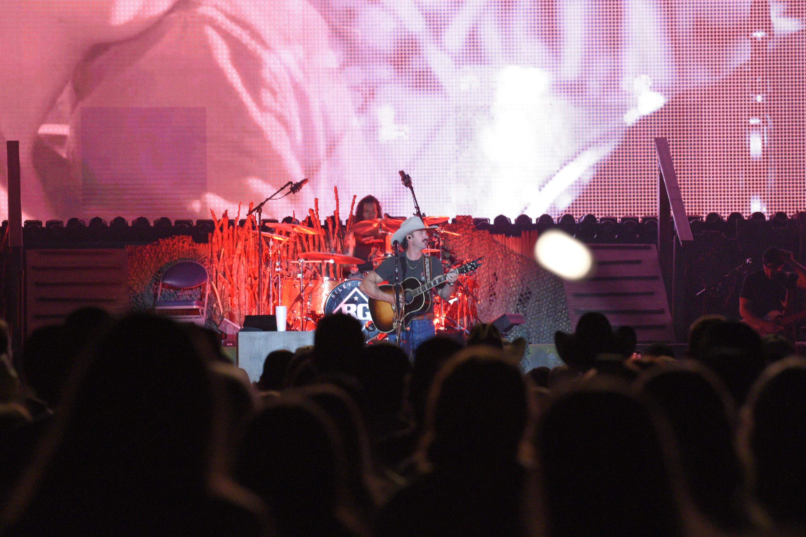 Country musician performing live on stage with band.