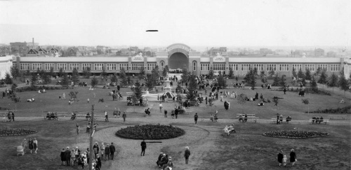 Historic garden with people and large building, 1930s.