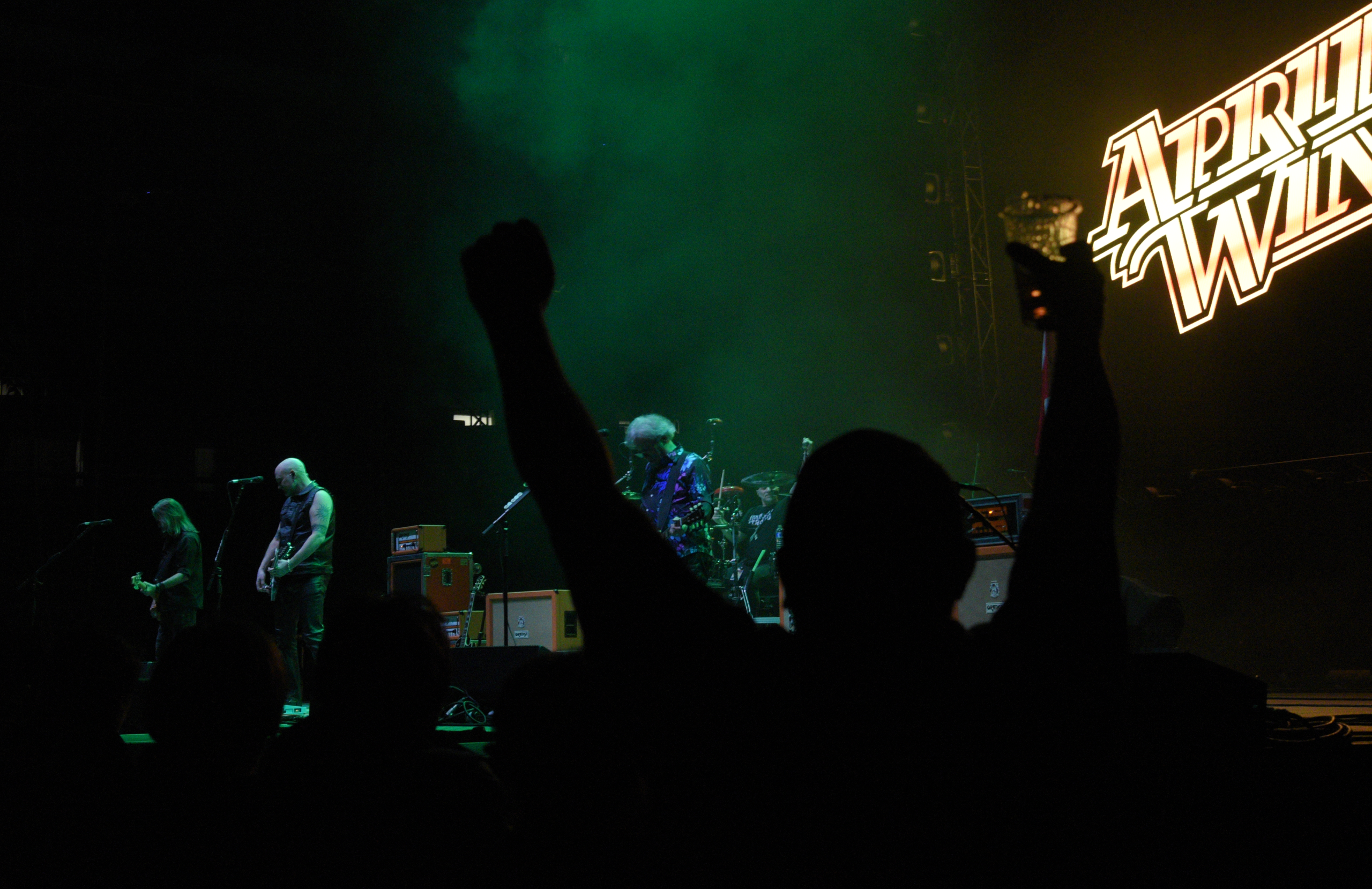 Rock band performing live on stage with crowd.