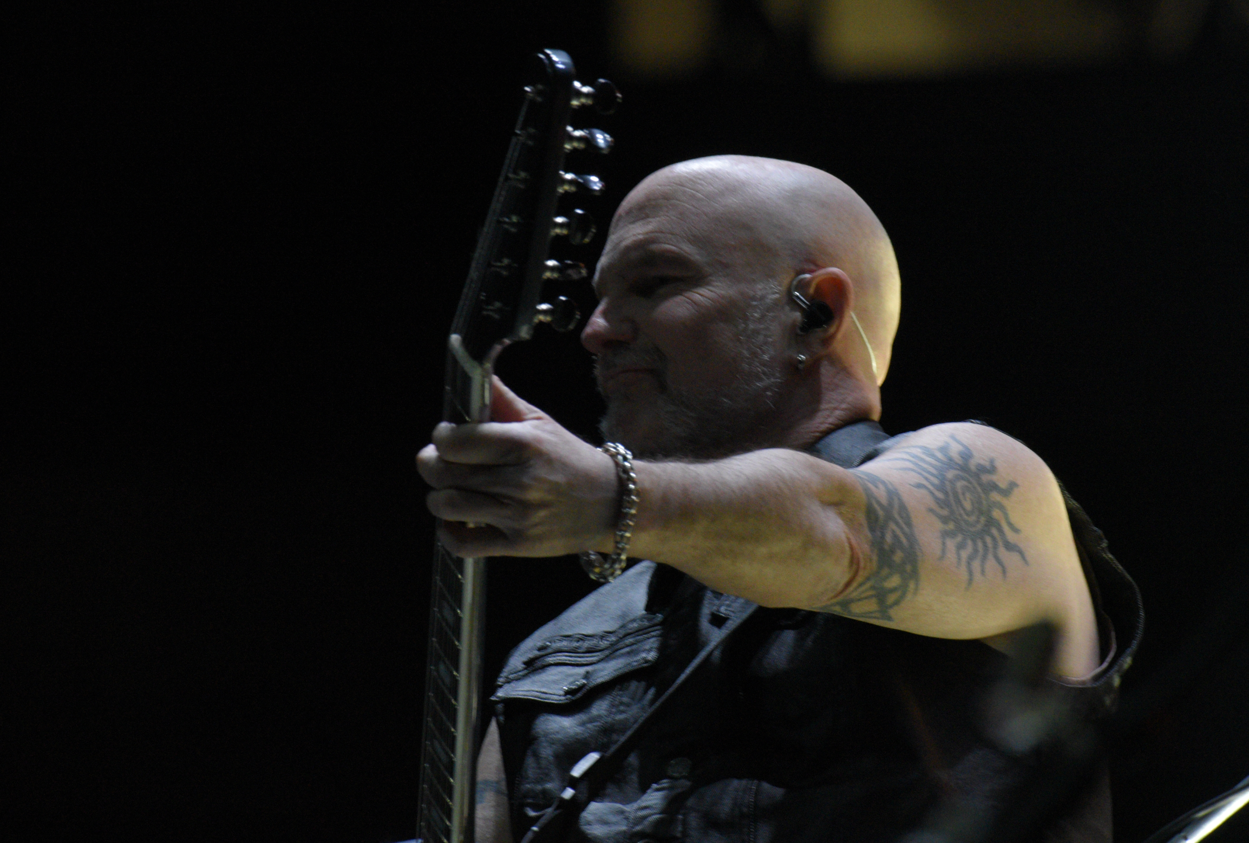 Musician playing electric guitar on stage.