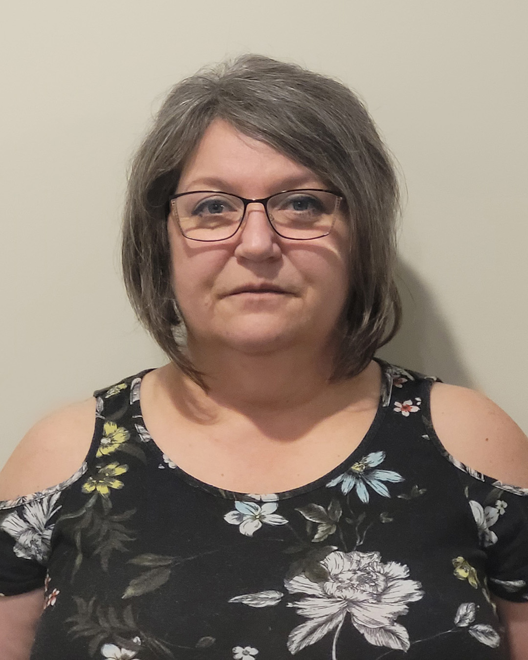 Woman in floral top with glasses