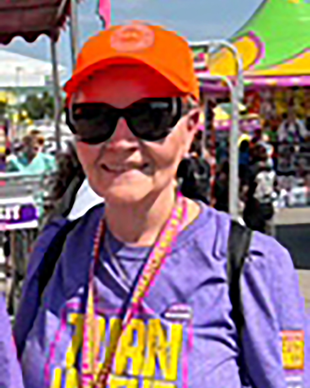 Person outdoors wearing orange cap and sunglasses