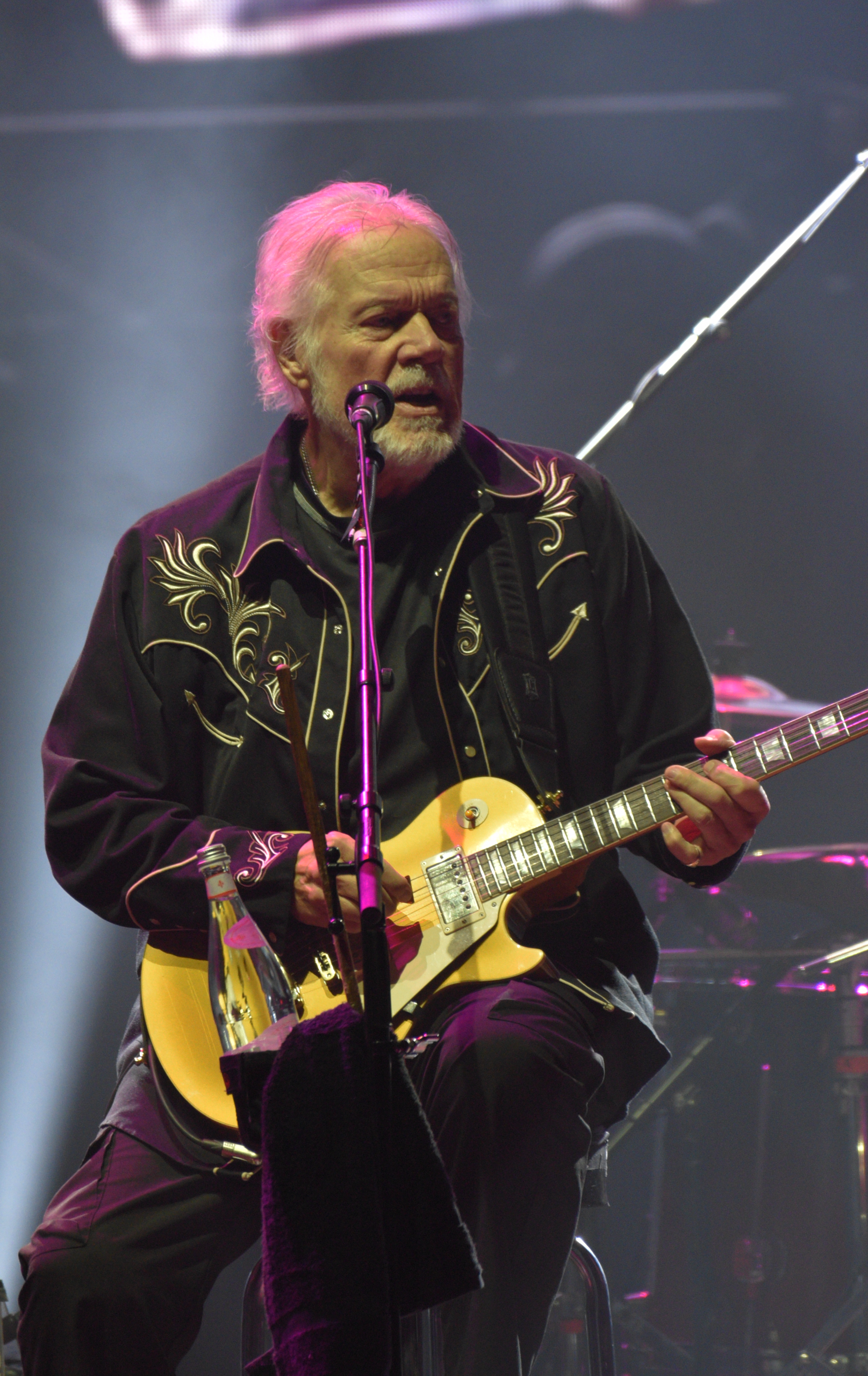 Musician performing on stage with guitar