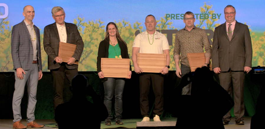 Group on stage holding awards at an event.
