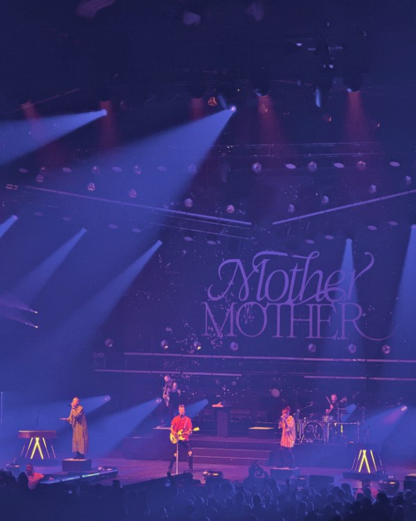 Band performing on stage with colorful lights.