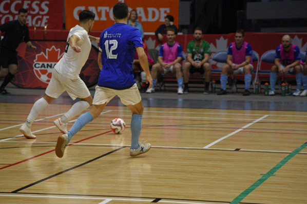 Indoor soccer match with players and benches