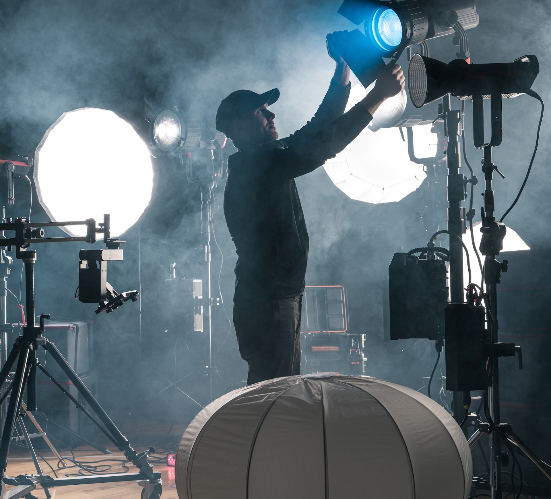 Lighting technician adjusting film set lights